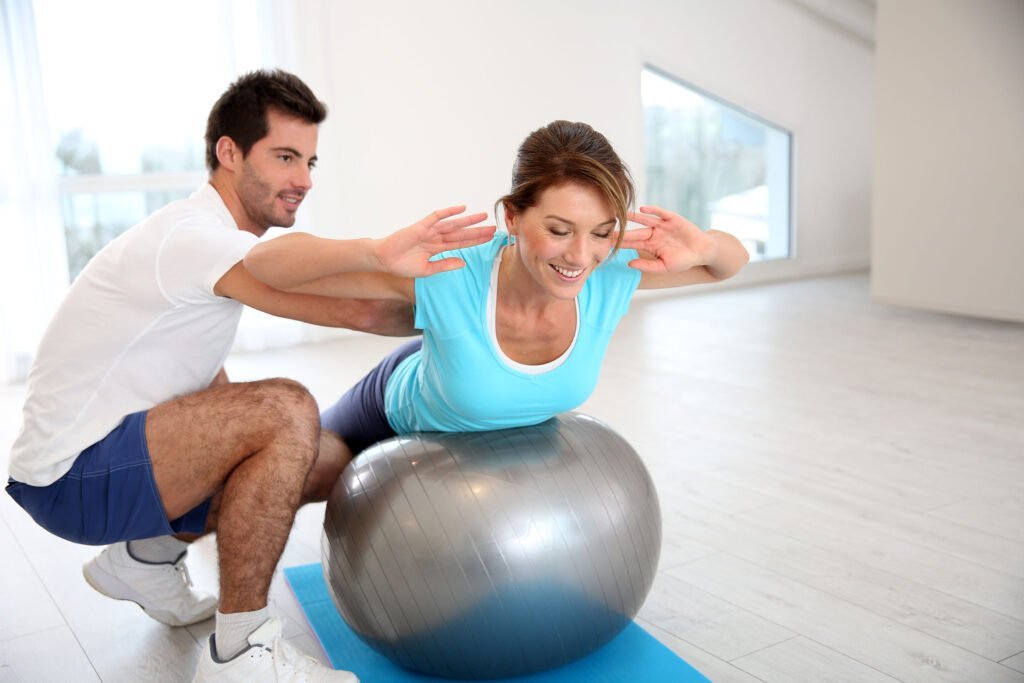 Coach et cliente Position allongé sur un ballon de gymnastique